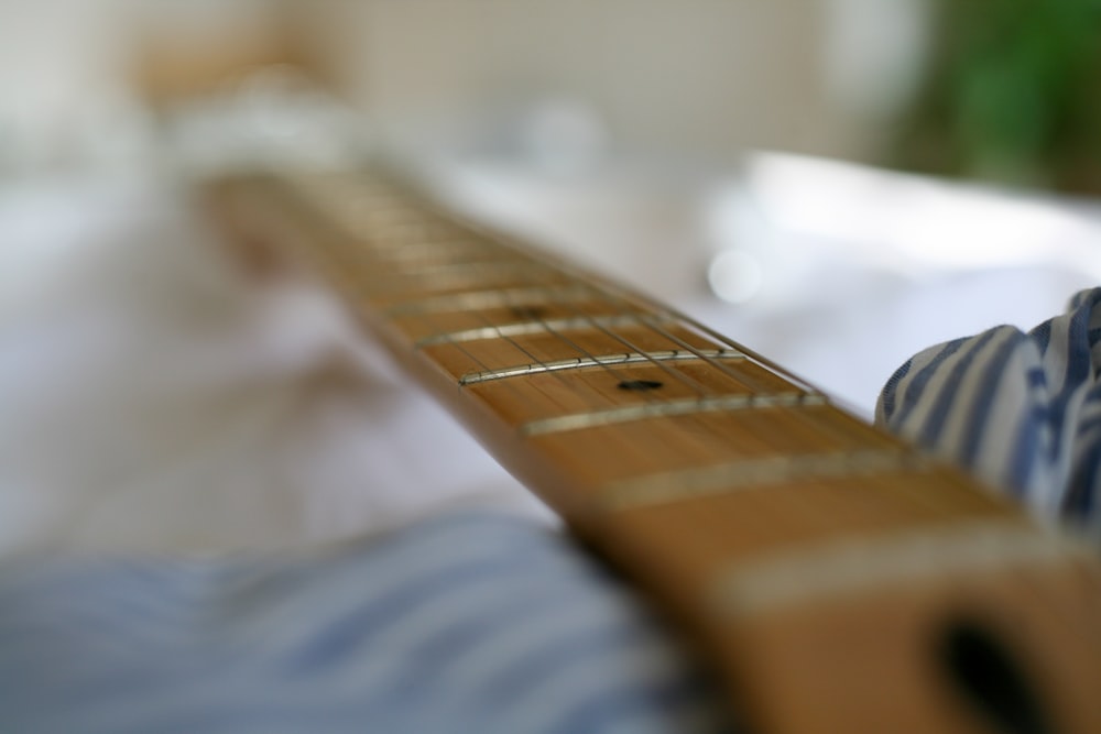 selective focus photography of brown wooden guitar neck