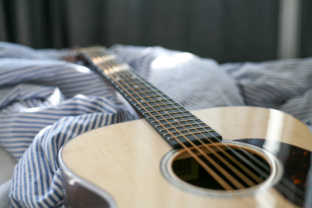 acoustic guitar on bed