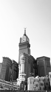 grayscale photo of buildings and a tower