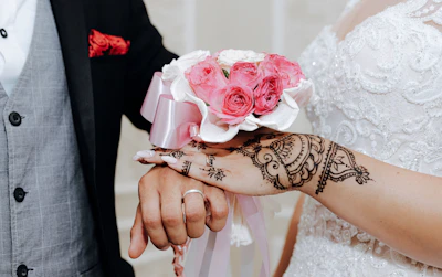 Close-up of a bride's hands adorned with detailed bridal mehndi patterns.