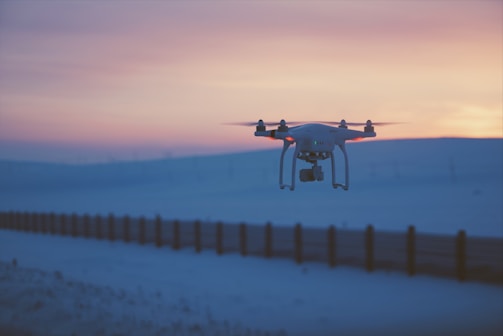 A drone flying over a scenic landscape capturing cinematic footage at sunset.