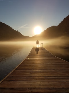 A thoughtful man standing at sunrise, symbolizing new beginnings.