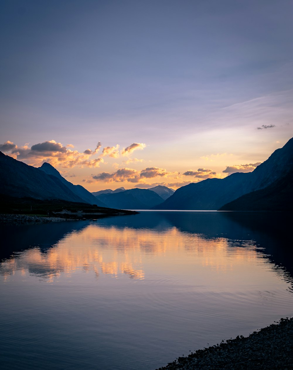 a body of water with mountains in the background