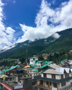 A scenic mountain town with colorful houses and lush green hills.