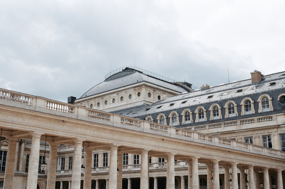 Graues und beigefarbenes Betongebäude unter weißen Wolken