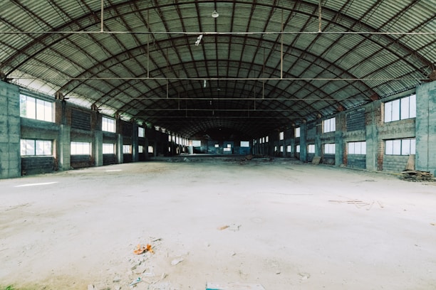 A wide shot of a spacious, clean warehouse with sunlight streaming through large windows.