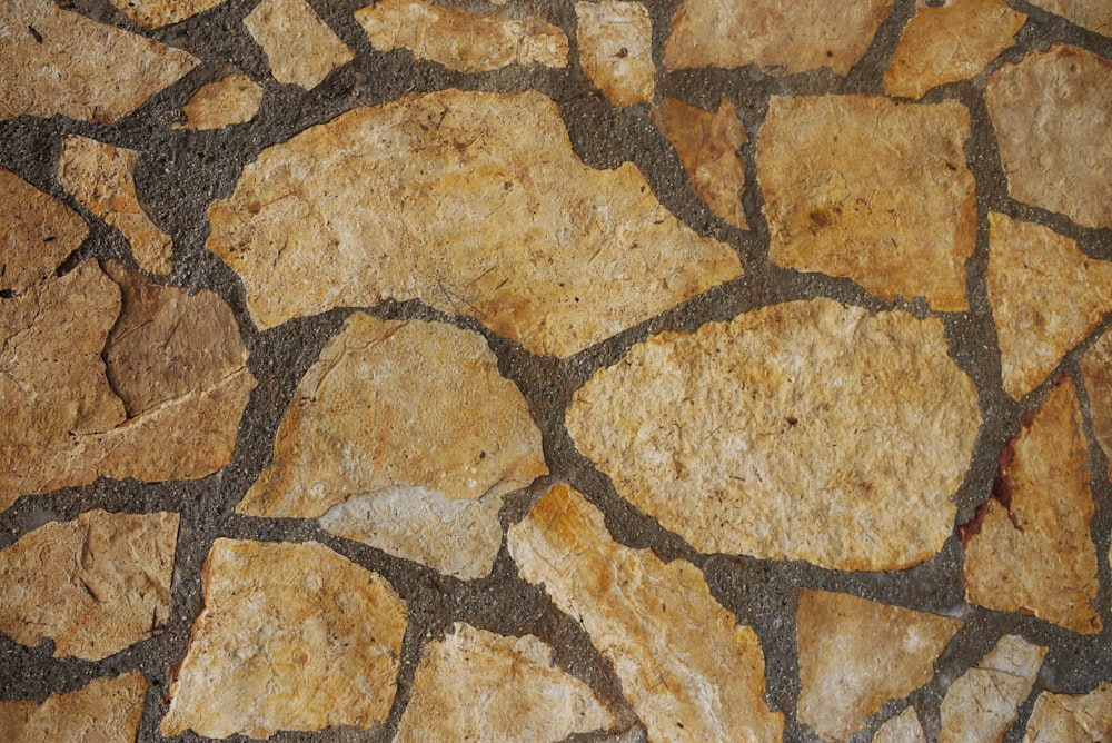 a close up of a stone wall with a red stop sign on it