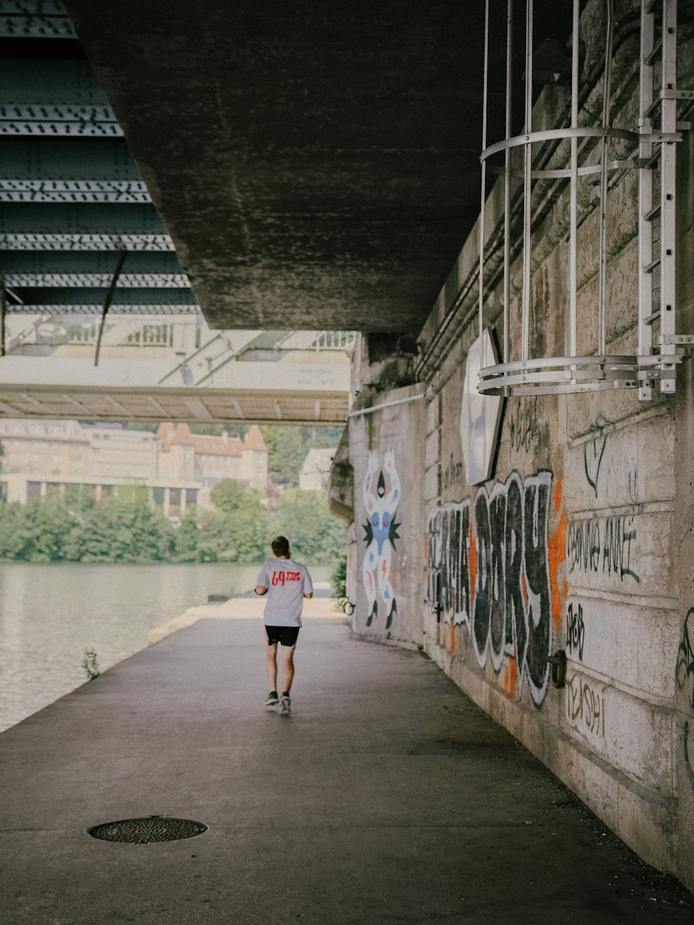 man wearing white T-shirt walking on sidewalk