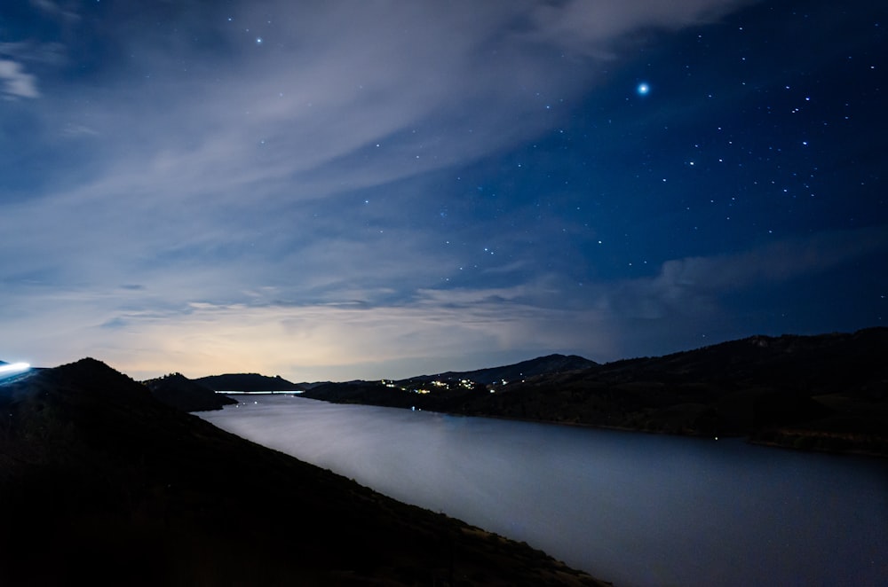 mountain near body of water at night