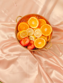 a bowl of sliced oranges and strawberries fruit juice gummies