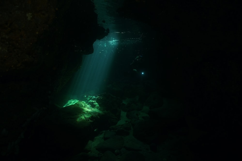 a light shines in the water from a cave