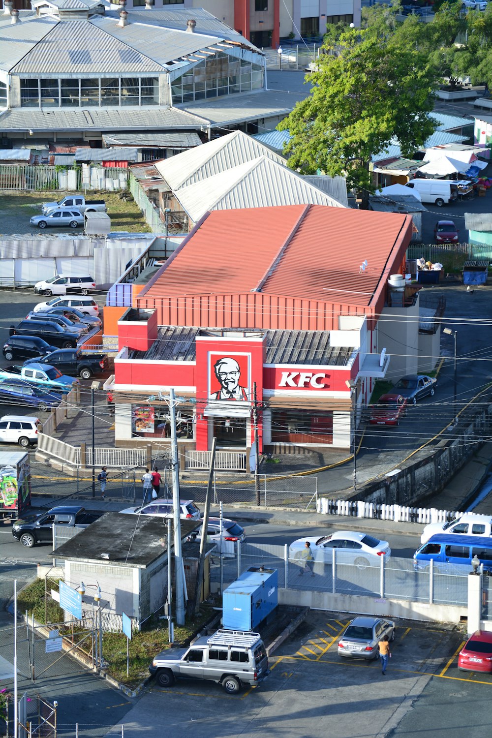 Edificio KFC junto a vehículos estacionados en el estacionamiento durante el día
