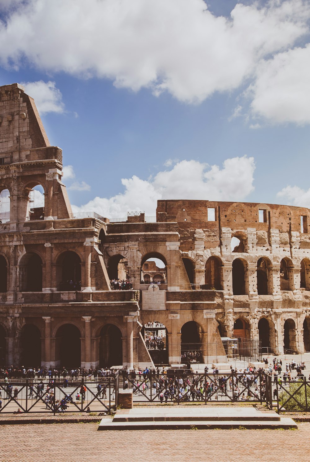 people near Colosseum in Rome, Italy under blue and white skies during daytime