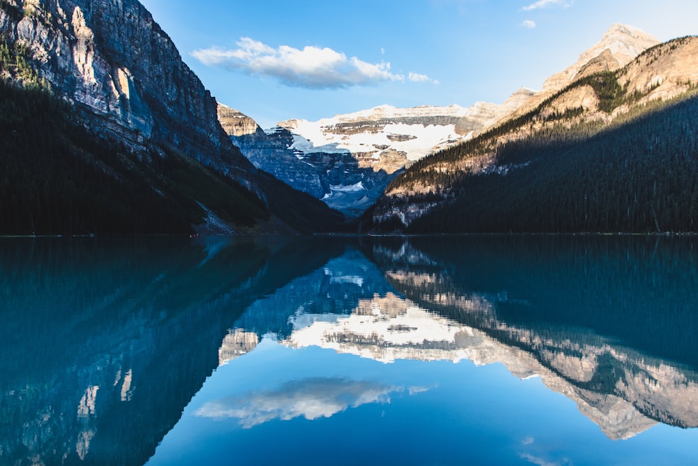 body of water between mountain during daytime