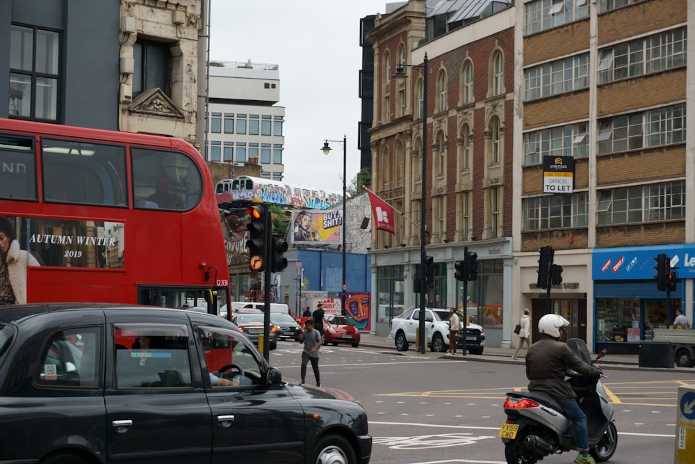 black car on road beside red bus