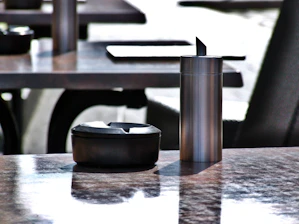 Close-up of a rose gold trivico chafing dish reflecting ambient light on a marble countertop.