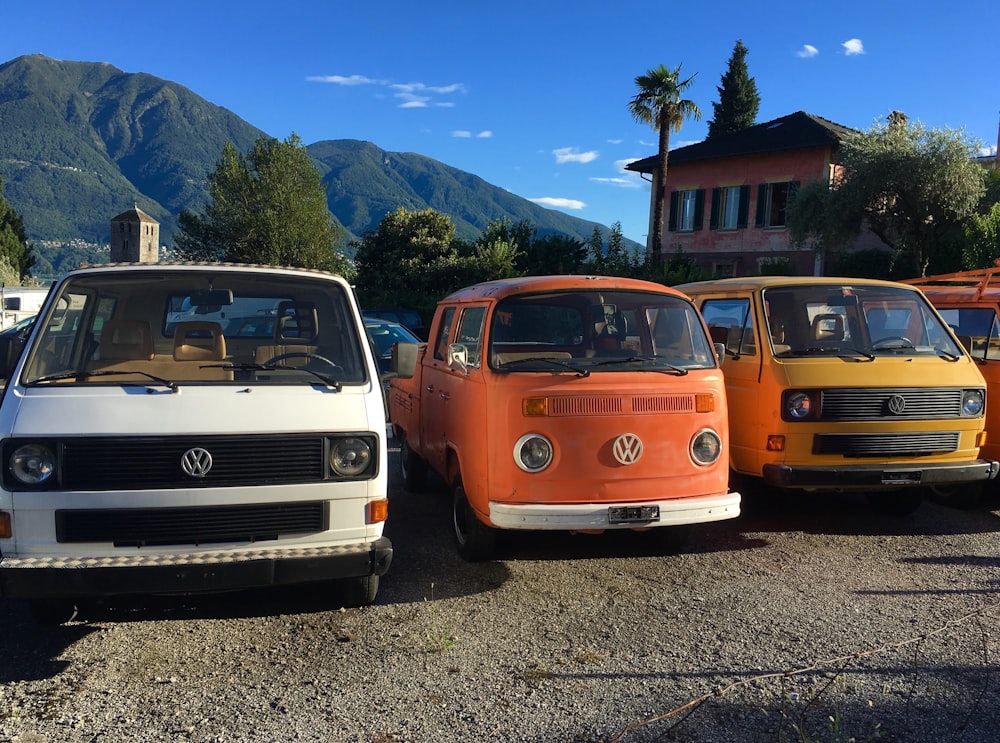 three assorted-color Volkswagen transporters