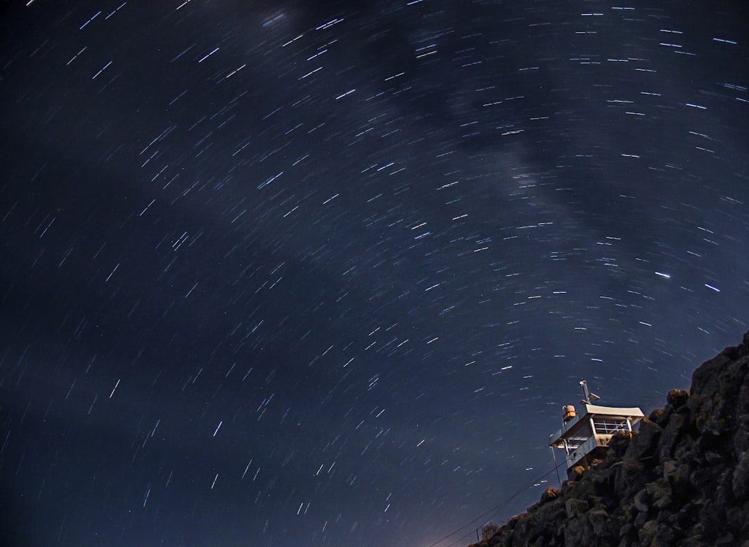 house at night, Star trails appear above the building. Long exposure photography