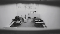 Close-up of a cleaner carefully wiping a desk with a microfiber cloth in a bright office space.