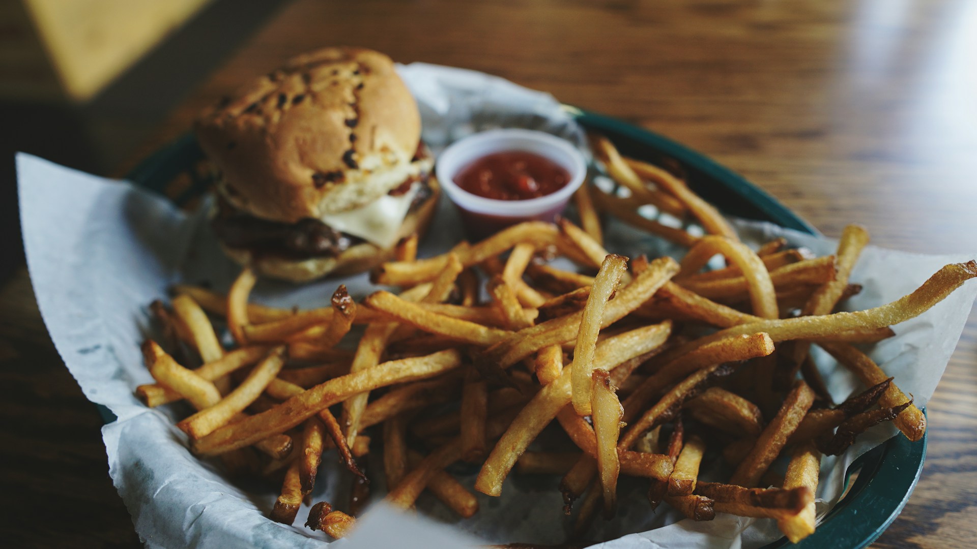 A vibrant plate of golden, crispy fries served alongside a delicious burger.