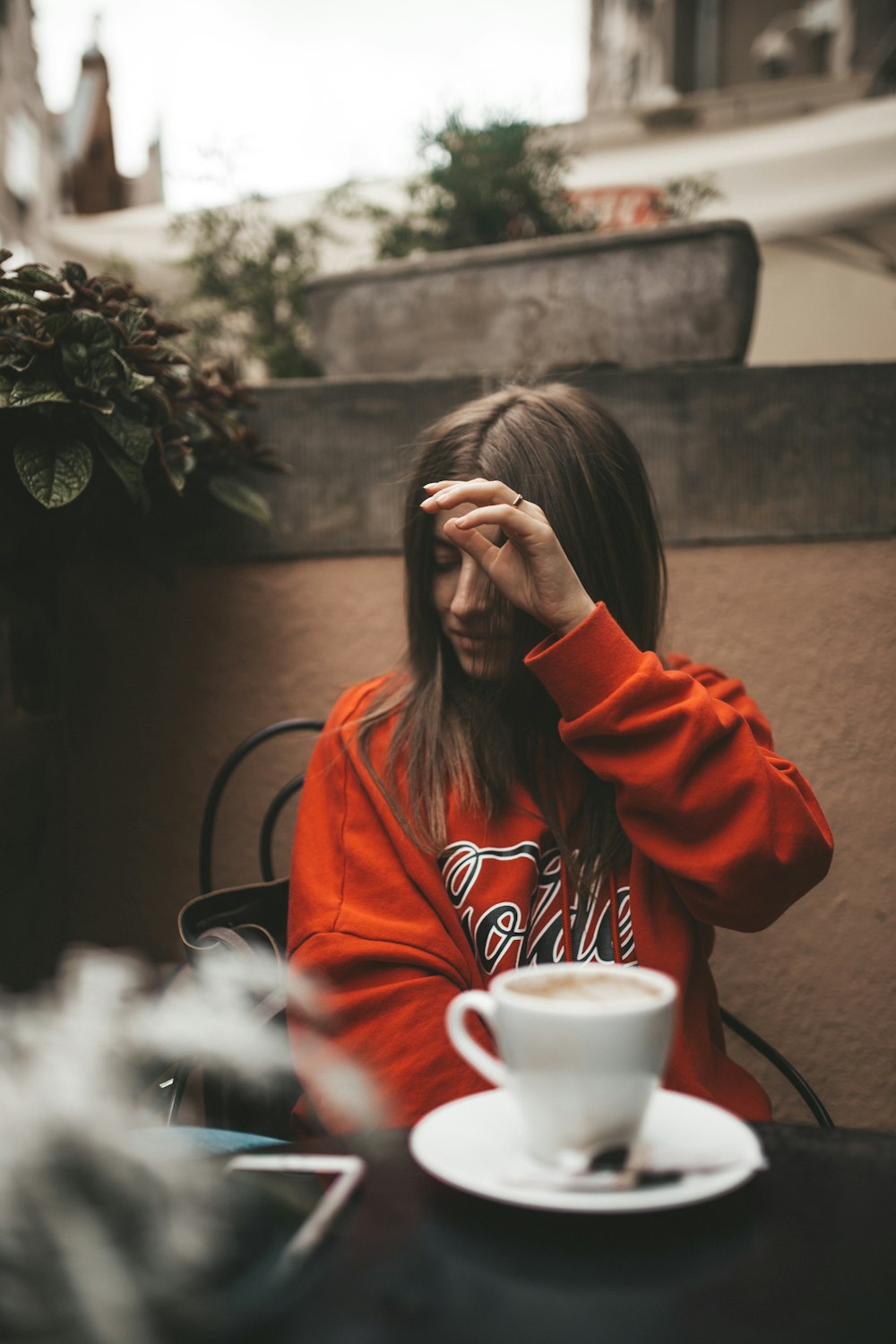 woman in red sweater sitting on chair front of table