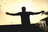 A silhouette of a man breaking free from heavy chains against a backdrop of glowing sunrise.