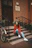 woman in red pullover hoodie sitting in front of closed door during daytime