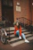 woman in red pullover hoodie sitting in front of closed door during daytime
