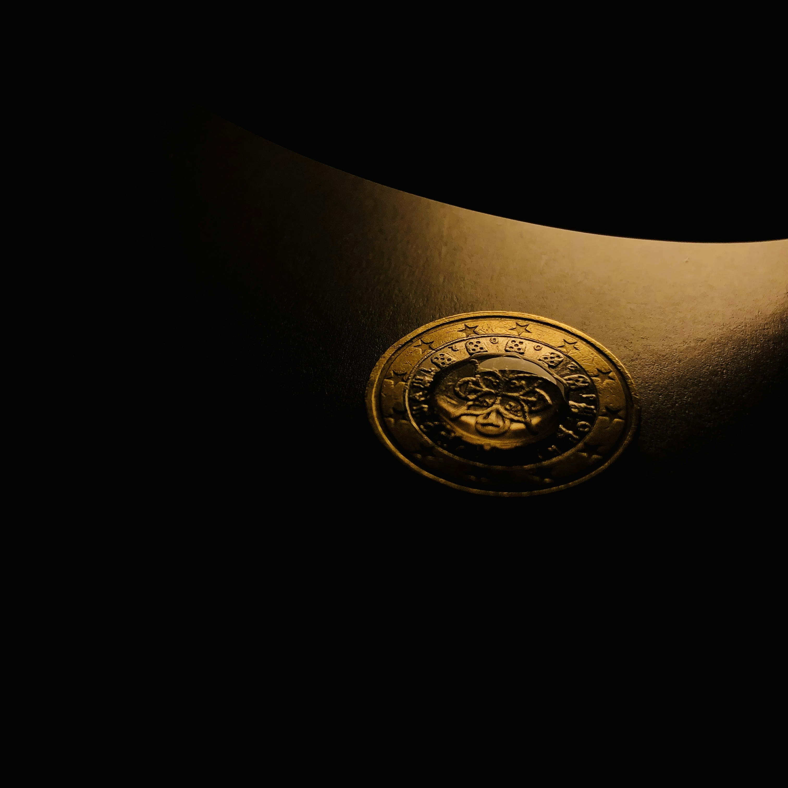 Gleaming gold Krugerrand coin on dark velvet background, warm amber numismatic lighting