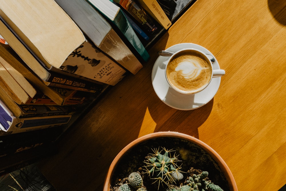 a cup of coffee sitting on top of a wooden table