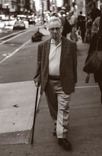 A stylish elderly man confidently navigating a city street with a Vidaluz wearable.