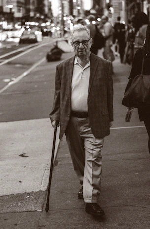 A stylish elderly man confidently navigating a city street with a Vidaluz wearable.