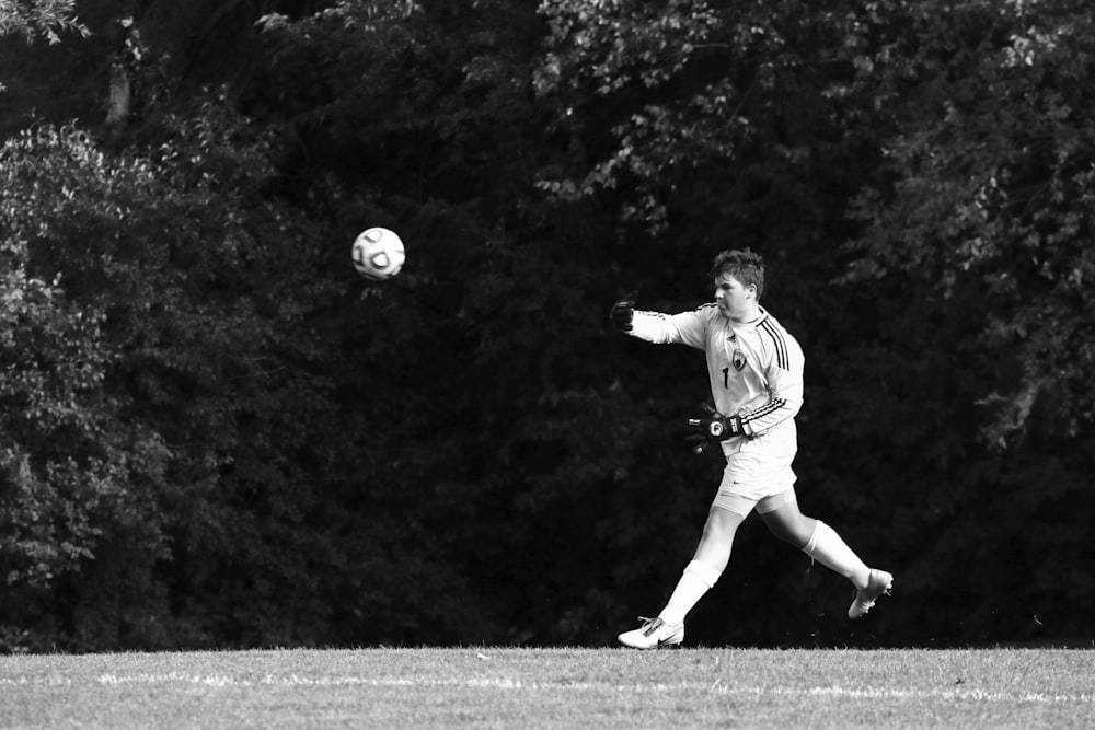 grayscale photography of man playing soccer