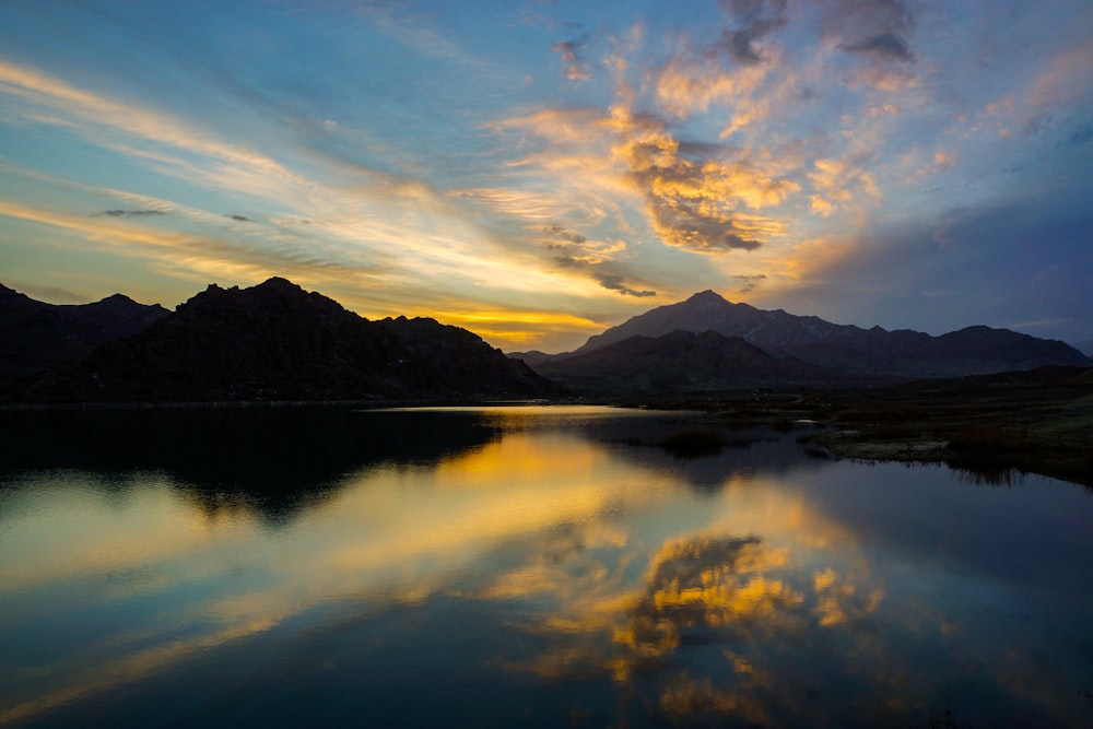 Silhouette eines Berges am Wasser während des Sonnenaufgangs