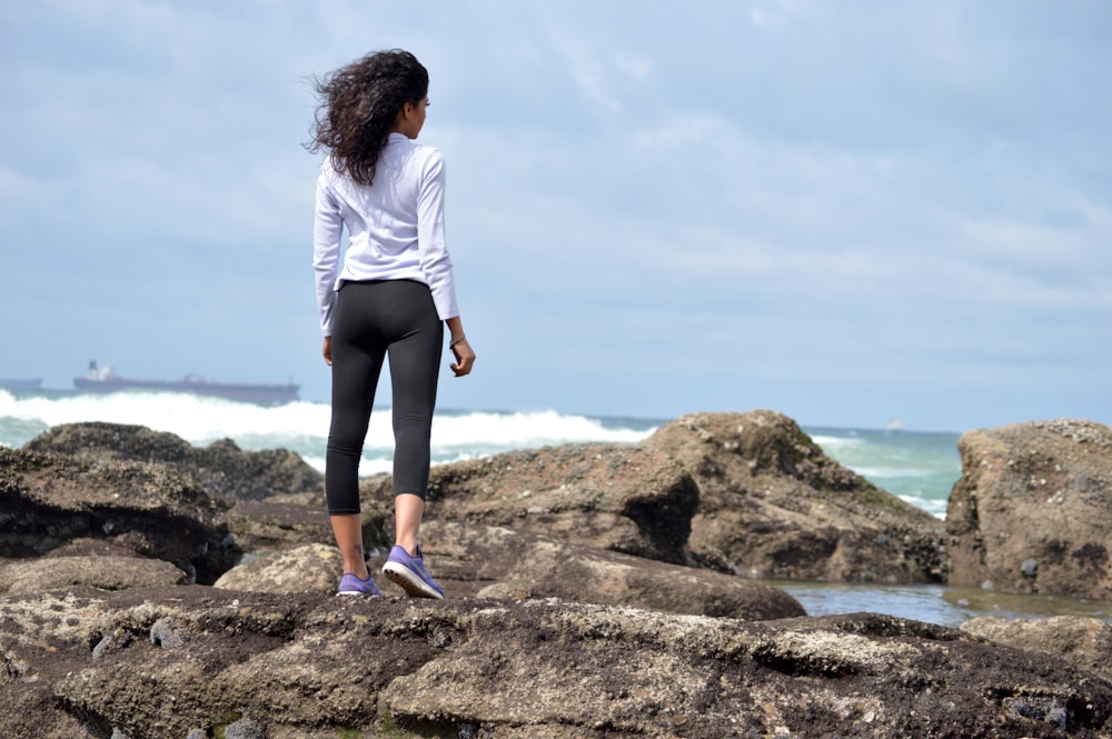 mulher em pé na rocha boulder