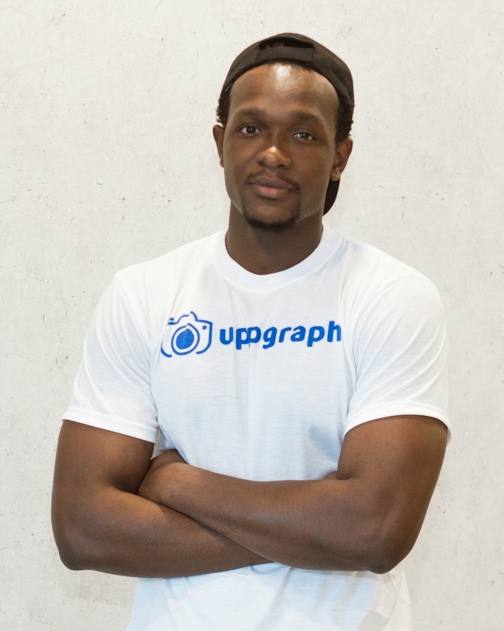 man in white t-shirt wearing black cap