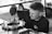 grayscale photo of man fixing gear