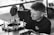 grayscale photo of man fixing gear