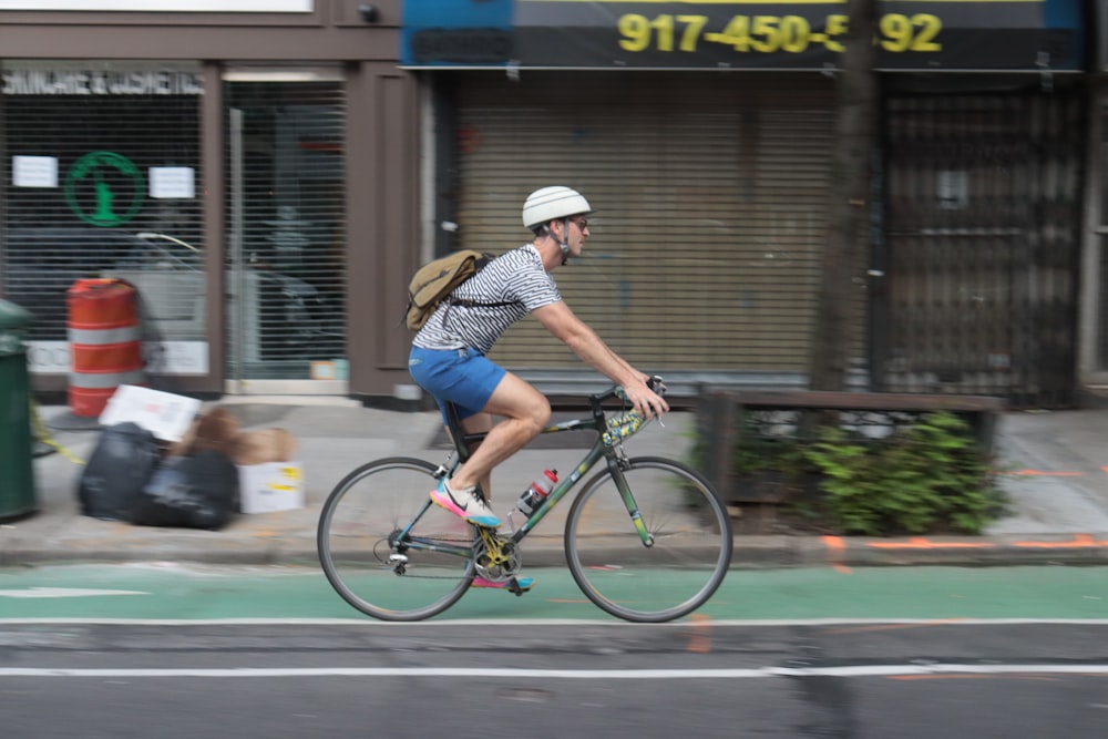 photo of man riding road bike in the middle of road scenery