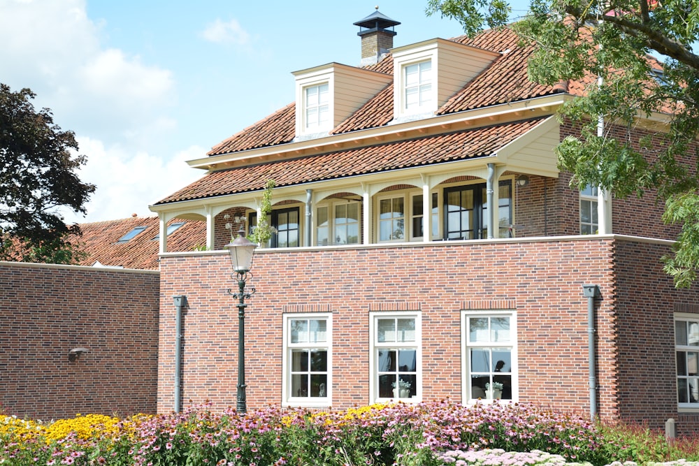 photo of brown and white painted house and meadow flowers