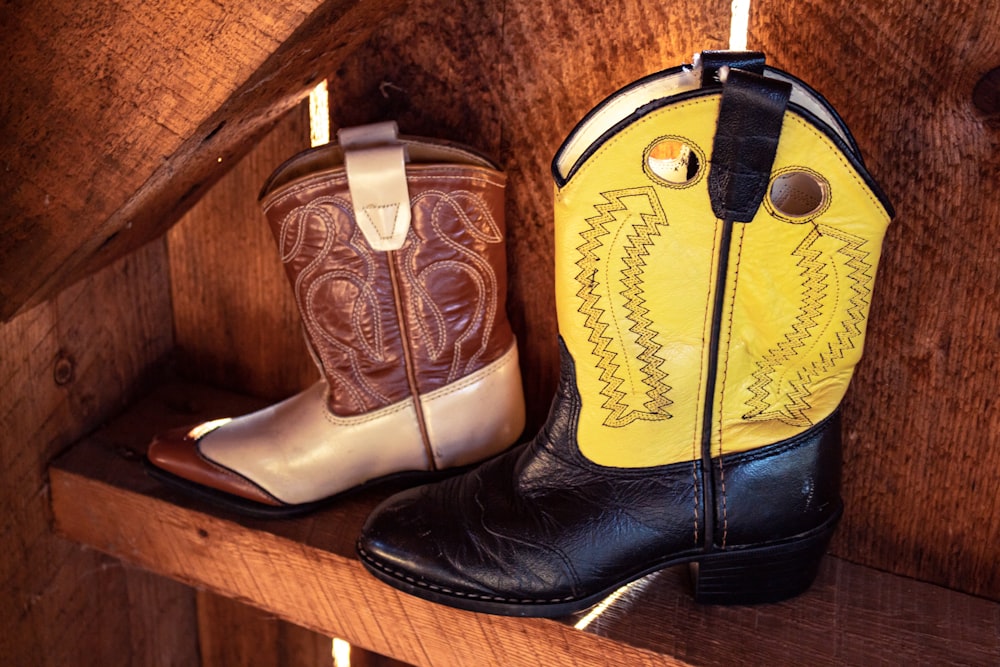 two unpaired leather cowboy boots in shelf