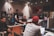 A group of diverse musicians collaborating in a modern studio space with laptops and audio equipment.