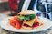 Close-up of a gourmet burger with fresh toppings on a wooden serving board.