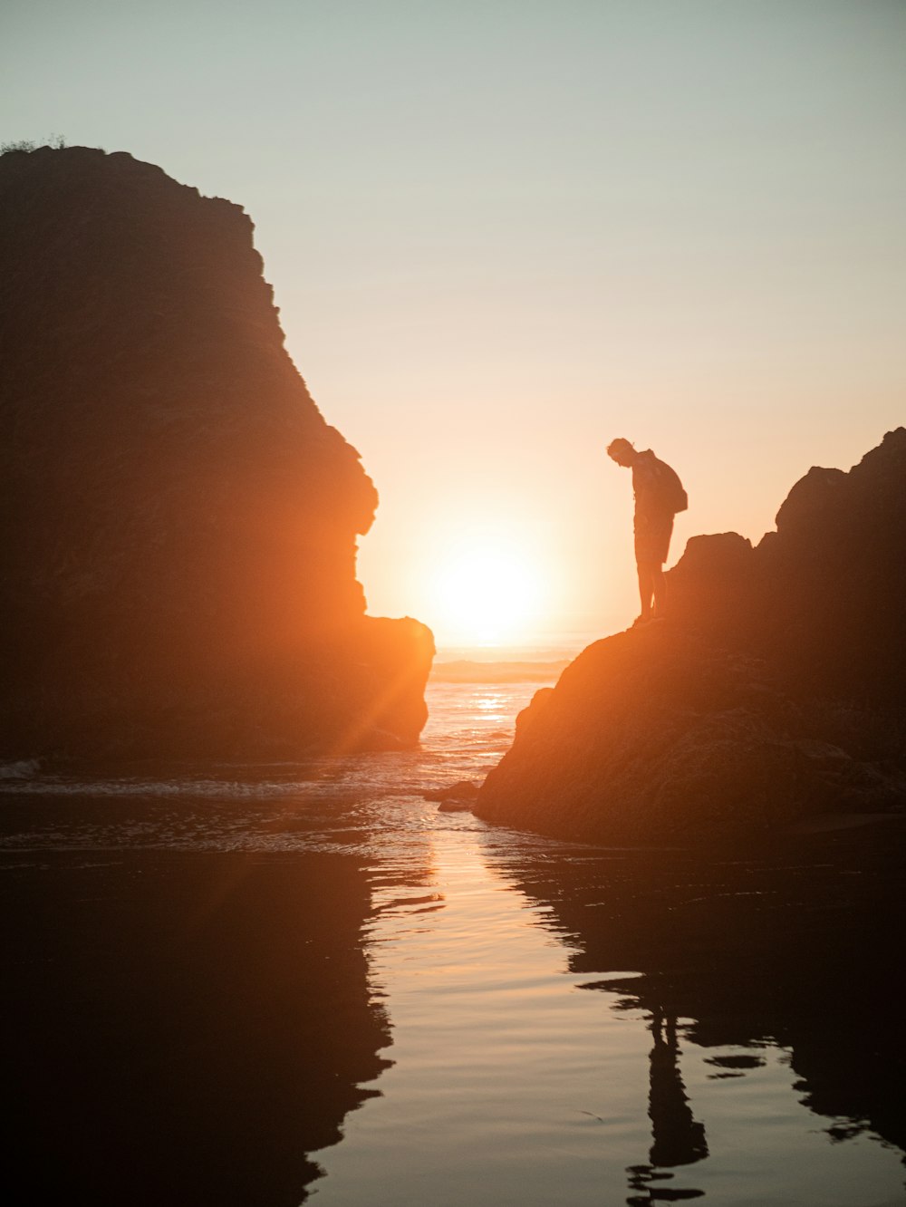 silhouette of person standing on rock