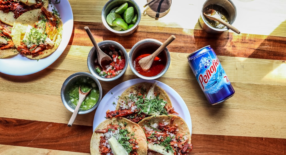 beverage can beside foods on plate and dips in bowls