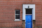 red brick building with closed door and window