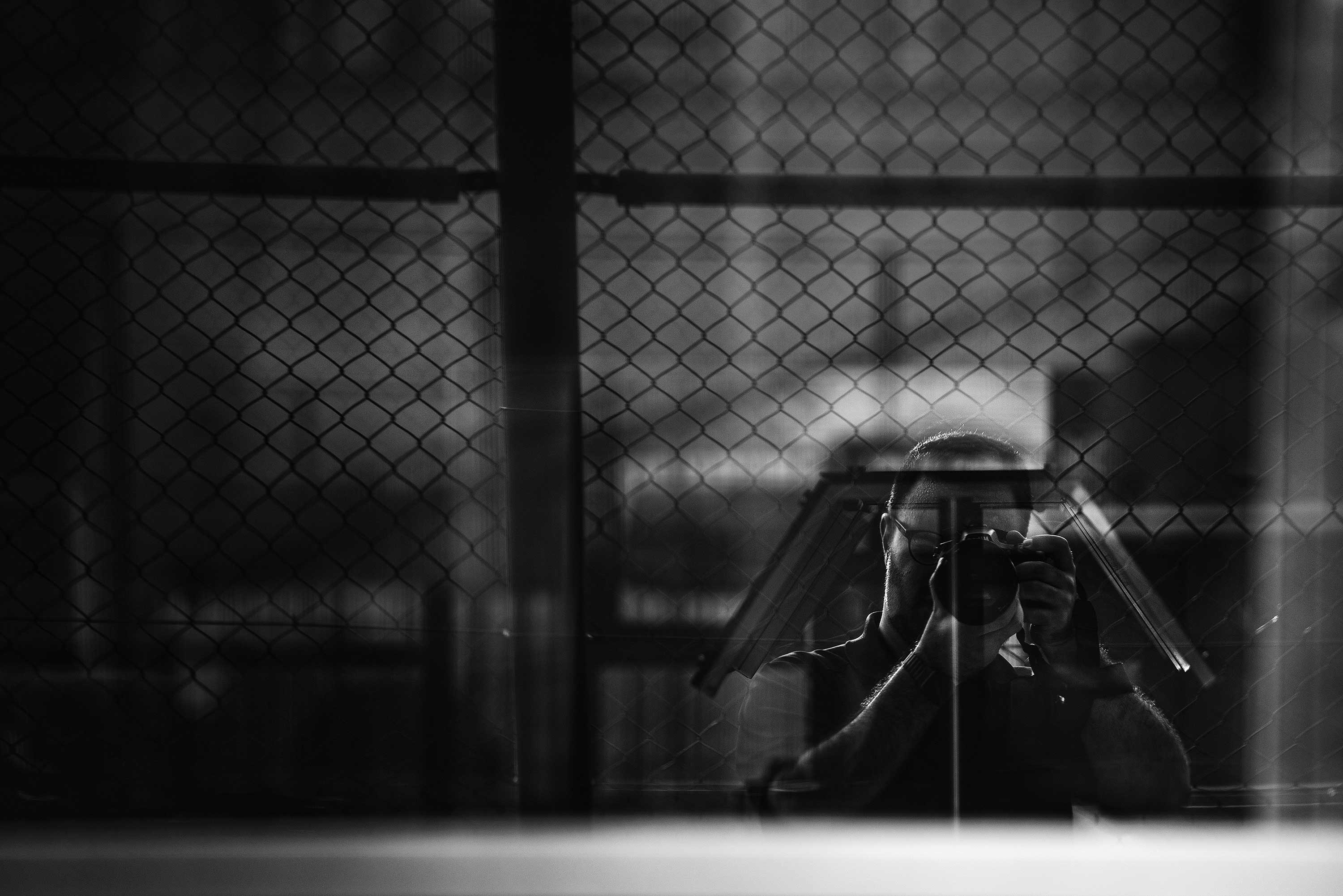 a person taking a picture through a fence