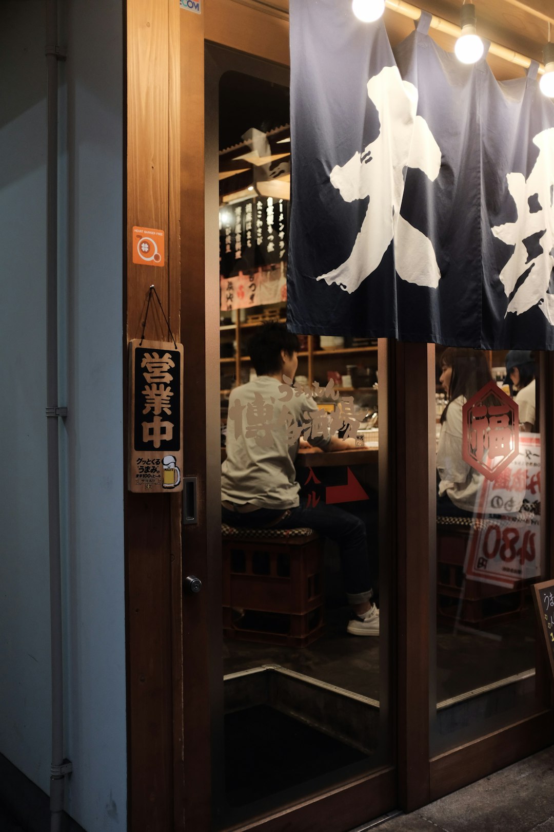 person in white top sitting in front of bar table