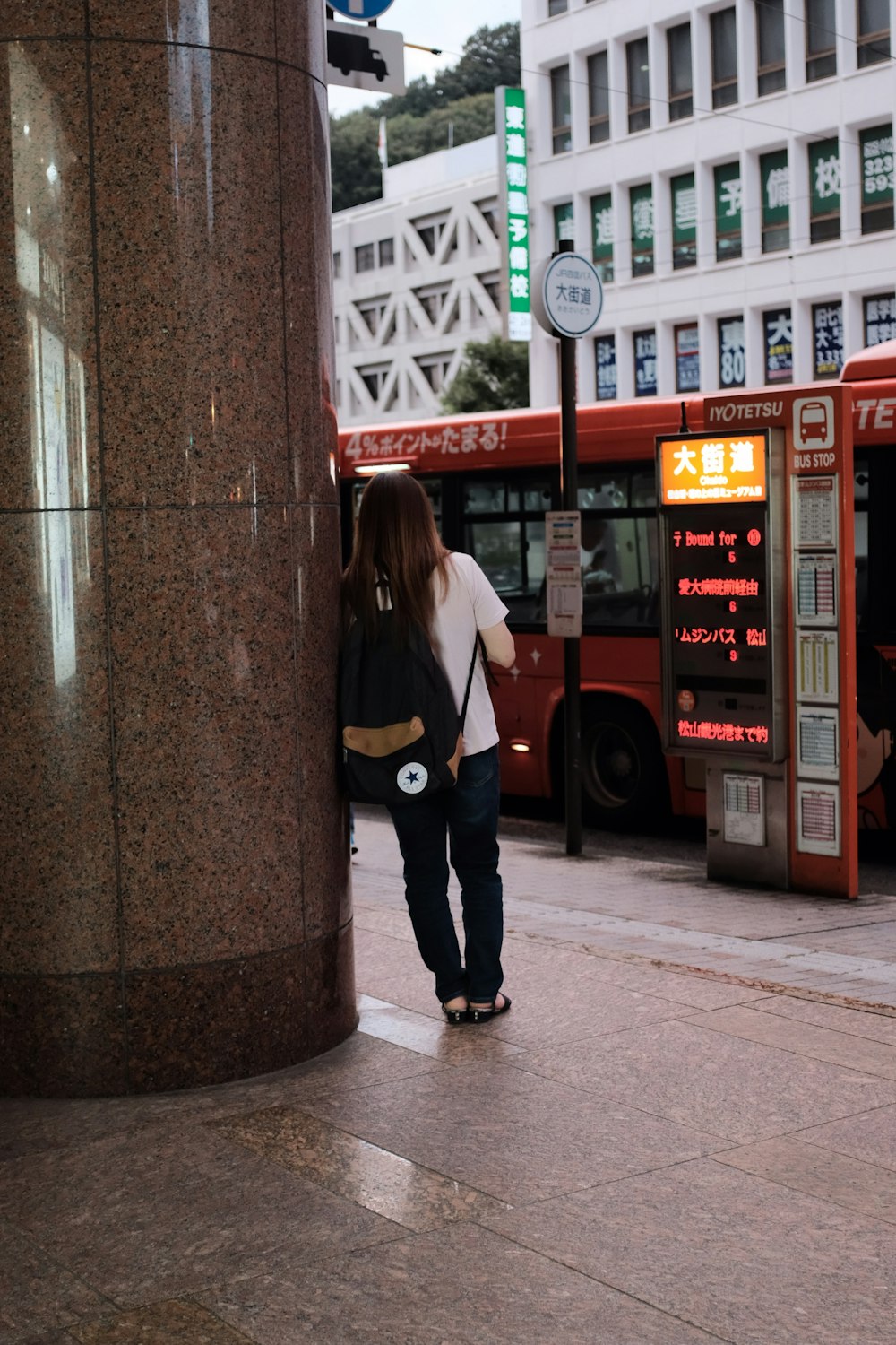 Foto de persona lleva una mochila Converse negra mientras se apoya en el  pilar – Imagen gratuita Humano en Unsplash