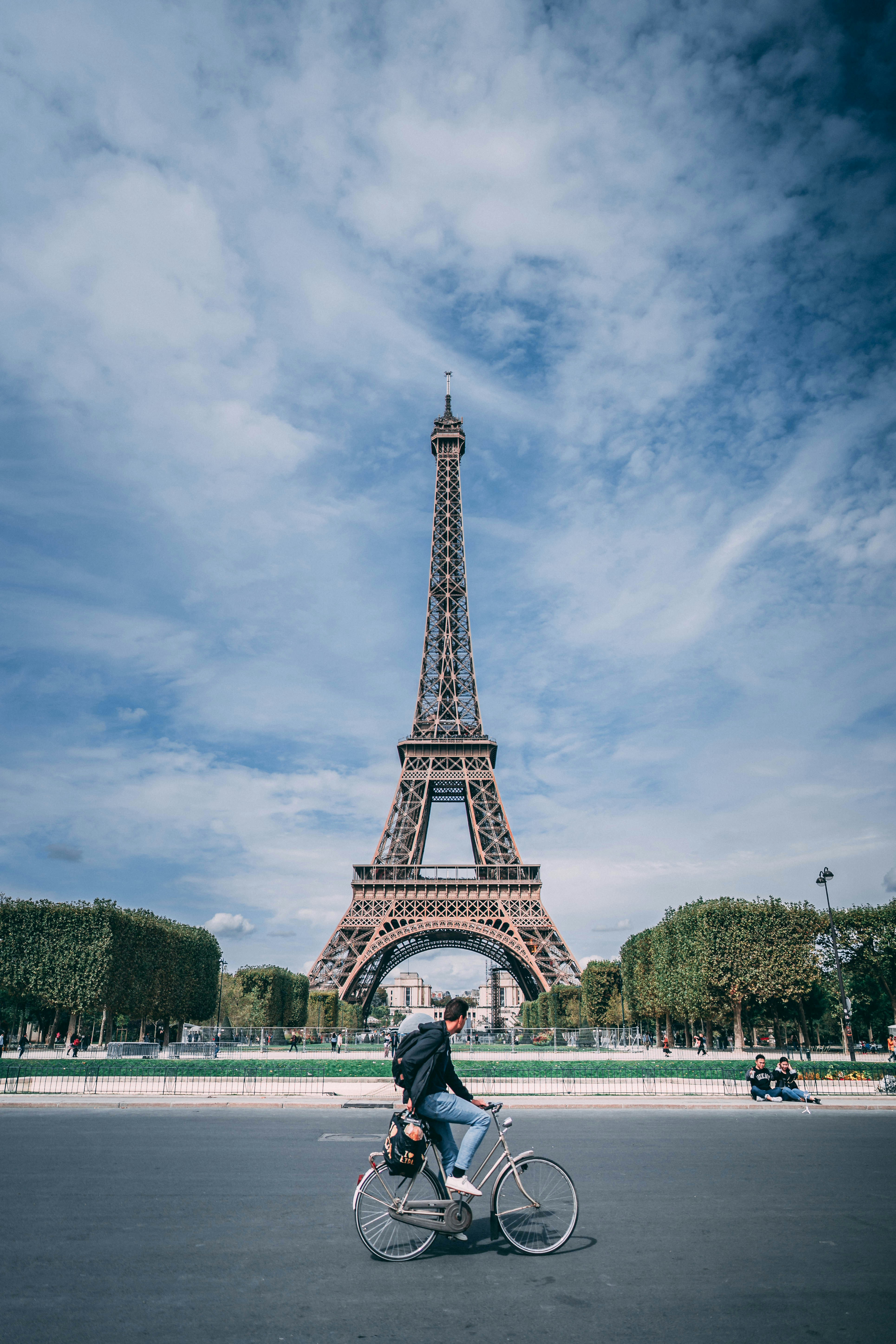 man riding on bicycle near eiffel tower during daytime
